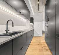 EXKLUZÍVNY MEZONETOVÝ 4i byt ( 103 m2 ), NADSTAVBA, KLÍMA, LOGGIA,NIVY - Kuchyňa v 4-izbovom byte na ulici Páričkova s drevenou podlahou a čiernym vybavením.
