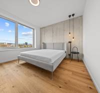 EXKLUZÍVNY MEZONETOVÝ 4i byt ( 103 m2 ), NADSTAVBA, KLÍMA, LOGGIA,NIVY - Svetlá spálňa s výhľadom, drevené podlahy, posteľ, nočný stolík, na ulici Páričkova.