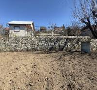 Predaj, záhradná chata Brodzany, pozemok 700 m2 - EX... - Drevená chata za kamenným múrom, obklopená stromami, v pokojnej časti záhrady.