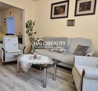 Predaj, rodinný dom Jelka - EXKLUZÍVNE HALO REALITY - Obývacia izba rodinného domu s pohodlným nábytkom a priestrannou kuchyňou na pozadí.