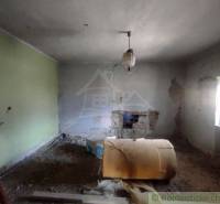 NOVÁ NIŽŠIA CENA ! Priestranný rodinný dom v pôvodnom stave v malej de - Izba v rodinnom dome v Brusníku s poškodenými stenami a rozobratou podlahou.