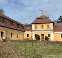 Rekonštruovaný barokový kaštieľ s kaplnkou a rozsiahlym parkom v Trávn - Historická žltá budova v Trávnici so šikmou strechou, obklopená záhradou. Zvláštne nehnuteľnosti.