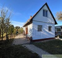 Chatka s rozsiahlou záhradou v lone prírody pri mlynskom náhone v Nový - Chata v Nových Zámkoch s patio, stromami a prívesom pod modrou oblohou.