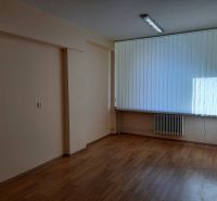 Prenájom kancelárií 21 m2 v centre Trnavy - Prázdne kancelárie s podlahou s dreveným dekorom a veľkými vertikálnymi žalúziami.