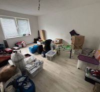 Rodinný dom Solčany - Izba v rodinnom dome s množstvom krabíc a položiek na podlahe s dreveným dekorom.