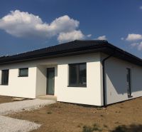 Výstavba moderného 4 izbového murovaného bungalovu - Rodinný dom v Trnave s bielou fasádou a tmavou strechou na pozemku.