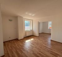 6-izbový rodinný dom s pozemkom 2218m2  | Horňany - Interiér rodinného domu s podlahou s dreveným dekorom, bielymi stenami a oknami.