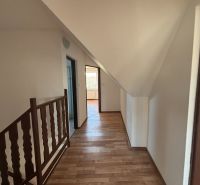 6-izbový rodinný dom s pozemkom 2218m2  | Horňany - Chodba s podlahou s dreveným dekorom v rodinnom dome, schodisko, dvere a steny.