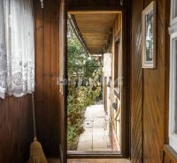 PREDAJ: Drevenica pri Ždiarskom potoku s príjemnou verandou, 135 m2, P - Chata s výhľadom na terén a drevenými obkladmi, vidno aj záhradu.