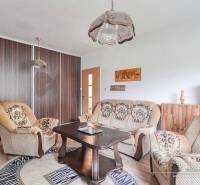 3-izbový byt v Šali na Vajanského ulici - Obývačka v 3-izbovom byte s pohodlným sedením a podlahou s dreveným dekorom.