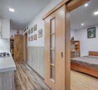 3-izbový byt v Šali na Vajanského ulici - Kuchynský kút s varnou doskou a posteľou, 3-izbový byt s podlahou s dreveným dekorom.