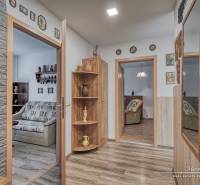 3-izbový byt v Šali na Vajanského ulici - Interiér 3-izbového bytu s podlahou s dreveným dekorom, dekorácie na stenách, zrkadlo.