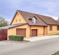 5-izbový rodinný dom s dvomi garážami v obci Špačince - Rodinný dom v Špačinciach na ulici Špačince s oranžovou fasádou a hnedou strechou.