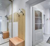 5-izbový rodinný dom s dvomi garážami v obci Špačince - Chodba s vešiakovou stenou a zrkadlom v rodinnom dome. Podlaha s dreveným dekorom.