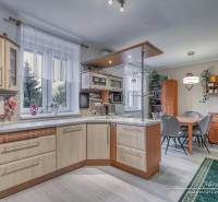 5-izbový rodinný dom s dvomi garážami v obci Špačince - Kuchyňa v rodinnom dome s podlahou s dreveným dekorom, vybavená kuchynským nábytkom.