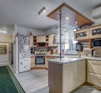 5-izbový rodinný dom s dvomi garážami v obci Špačince - Kuchyňa v rodinnom dome s podlahou s dreveným dekorom, spotrebiče a vybavenie.