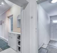 5-izbový rodinný dom s dvomi garážami v obci Špačince - Chodba v rodinnom dome s bielymi stenami a praktickým úložným priestorom.