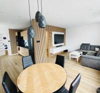 NA PRENÁJOM NOVOZREKONŠTRUOVANÝ 2-IZBOVÝ BYT, UL. ROŽŇAVSKÁ - Štýlový interiér 2-izbového bytu s podlahou s dreveným dekorom a pohodlnou sedačkou.