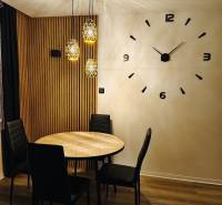 NA PRENÁJOM NOVOZREKONŠTRUOVANÝ 2-IZBOVÝ BYT, UL. ROŽŇAVSKÁ - Jedálenský kút v 2-izbovom byte s kruhovým stolom a podlahou s dreveným dekorom.