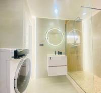 NA PRENÁJOM NOVOZREKONŠTRUOVANÝ 2-IZBOVÝ BYT, UL. ROŽŇAVSKÁ - Kúpeľňa 2-izbového bytu so sprchovým kútom, práčkou a zrkadlom s LED podsvietením.
