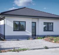 Novostavba 4-izbového rodinného domu v obci Slov.Nová Ves - Rodinný dom v Slovenskej Novej Vsi na ulici Slovenská Nová Ves s tmavou strechou a parkoviskom.