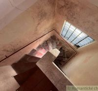 Starý dom s dušou – čaká na nový život v jednej z najkrajších ulíc Nov - Schodisko v rodinnom dome s veľkým oknom a opotrebovanými stenami.
