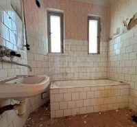 Starý dom s dušou – čaká na nový život v jednej z najkrajších ulíc Nov - Kúpeľňa v rodinnom dome s oprýskanými stenami a starou vaňou.