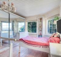 Rekreačná chata s úžasným výhľadom v prestížnej lokalite Devín - Svetlá izba v rodinnom dome s posteľou, zrkadlom a podlahou s dreveným dekorom.