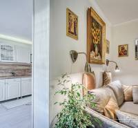 Rekreačná chata s úžasným výhľadom v prestížnej lokalite Devín - Interiér rodinného domu s bielou kuchynskou linkou a útulným kútikom s pohovkou a dekoráciami.