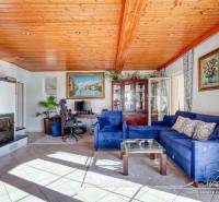 Rekreačná chata s úžasným výhľadom v prestížnej lokalite Devín - Obývačka v rodinnom dome s krbom, modrou sedačkou a podlahou s dreveným dekorom.