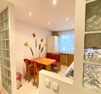 NA PRENÁJOM PRIESTRANNÝ 3-IZBOVÝ BYT V SKVELEJ LOKALITE, UL. SLOBODY - Jedálenský kút v 3-izbovom byte s dreveným stolom a červenými stoličkami.