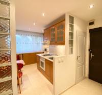 NA PRENÁJOM PRIESTRANNÝ 3-IZBOVÝ BYT V SKVELEJ LOKALITE, UL. SLOBODY - Kuchyňa v 3-izbovom byte s dreveným dekorom a sklenenou tehlovou stenou.