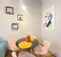 NA PRENÁJOM NADŠTANDARDNÝ 2-IZBOVÝ BYT V CENTRE MESTA - Jedálenský kút v 2-izbovom byte s okrúhlym stolom a dekoráciami na stene.