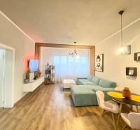 NA PRENÁJOM NADŠTANDARDNÝ 2-IZBOVÝ BYT V CENTRE MESTA - Obývacia izba v 2-izbovom byte s podlahou s dreveným dekorom a pohodlnou sedačkou.