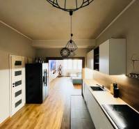 NA PRENÁJOM NADŠTANDARDNÝ 2-IZBOVÝ BYT V CENTRE MESTA - Kuchyňa v 2-izbovom byte s podlahou s dreveným dekorom, viditeľná je aj obývacia časť.