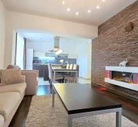 HD REALITY, Vám ponúka na Predaj 3-izbový Apartmán + Garážové státie - Interiér 3-izbového bytu s krbom, podlahou s dreveným dekorom a pohodlnou sedacou súpravou.