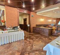 HD REALITY, Vám ponúka na Predaj 3-izbový Apartmán + Garážové státie - Reštaurácia s vínami, stolom s jedlom, drevenou výzdobou a presvetleným sedením.