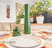 REZERVOVANÉ | NA PREDAJ 3-IZBOVÝ BYT S TERASOU, BLATNÁ NA OSTROVE - Jedálenský stôl v 3-izbovom byte s kvetinovým obrusom a dekoráciami.