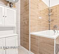 REZERVOVANÉ | NA PREDAJ 3-IZBOVÝ BYT S TERASOU, BLATNÁ NA OSTROVE - Kúpeľňa s vaňou, bielymi skrinkami a obkladom v 3-izbovom byte.