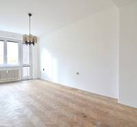 SEČOVSKÁ, 2-i tehlový byt, 56 m2, orientácia V a Z - OBKLOPENÝ ZELEŇOU - Svetlá miestnosť v 2-izbovom byte s podlahou s dreveným dekorom a závesným svietidlom.