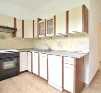 SEČOVSKÁ, 2-i tehlový byt, 56 m2, orientácia V a Z - OBKLOPENÝ ZELEŇOU - Kuchyňa v 2-izbovom byte s bielou linkou a dlažbou.