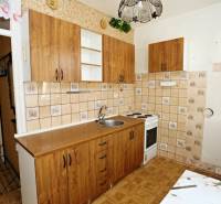 ÚTULNÝ, SVETLÝ 2 IZB.BYT S PRÍJEMNÝM VÝHĽADOM, DETVA - Kuchyňa s drevenými skrinkami v 2-izbovom byte a podlahou s dreveným dekorom.