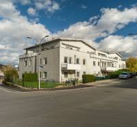 Slnečný 3i byt pod lesom, 74m2, balkón, parking, pivnica, Hainburg - Ulica Hainburg, Brunnenstrasse s bytovým domom a jesennou prírodou v Hainburg an der Donau.