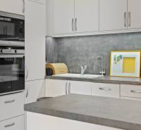 Slnečný 3i byt pod lesom, 74m2, balkón, parking, pivnica, Hainburg - Štýlová kuchyňa v 3-izbovom byte s bielymi skrinkami a tmavou pracovnou doskou.