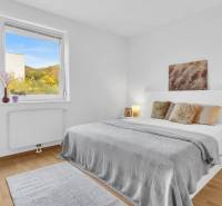 Slnečný 3i byt pod lesom, 74m2, balkón, parking, pivnica, Hainburg - Svetlá spálňa v 3-izbovom byte s podlahou s dreveným dekorom a dekoratívnymi detailmi.