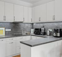 Slnečný 3i byt pod lesom, 74m2, balkón, parking, pivnica, Hainburg - Kuchyňa v 3-izbovom byte: biela linka, šedá pracovná doska, spotrebiče, jedálenský stôl.