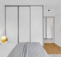 Slnečný 3i byt pod lesom, 74m2, balkón, parking, pivnica, Hainburg - Spálňa v 3-izbovom byte s posteľou, skriňou a podlahou s dreveným dekorom.