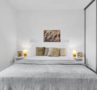 Slnečný 3i byt pod lesom, 74m2, balkón, parking, pivnica, Hainburg - Svetlá spálňa s posteľou, vankúšmi a šatníkovou skriňou v 3-izbovom byte.