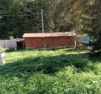 Hospodárska usadlosť  - Záhrada pri rodinnom dome v Horných Hámroch s dreveným prístreškom obklopená zeleňou.