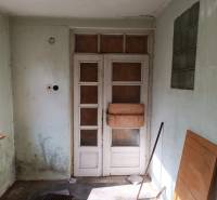 Hospodárska usadlosť  - Časť interiéru rodinného domu s presklenými dverami a stenou s malými oknami.